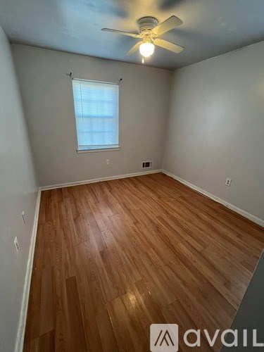A room with wooden flooring and a ceiling fan.