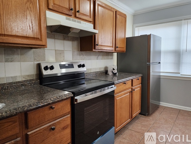 A kitchen with wooden cabinets and black appliances.