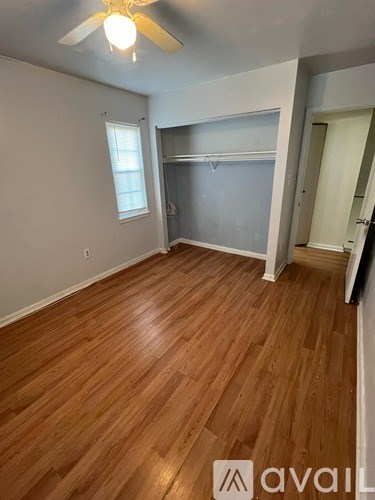 A room with wooden flooring and a ceiling fan.
