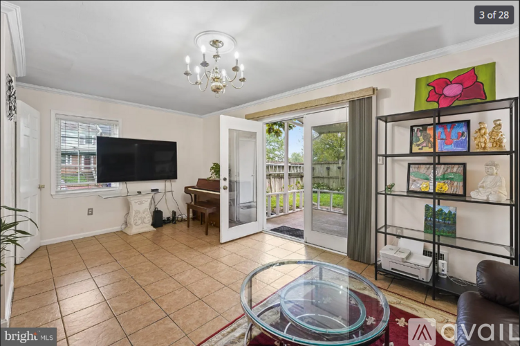 A living room with a glass coffee table and a flat screen TV.