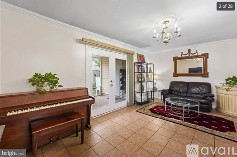 A living room with a piano, a couch, and a mirror.