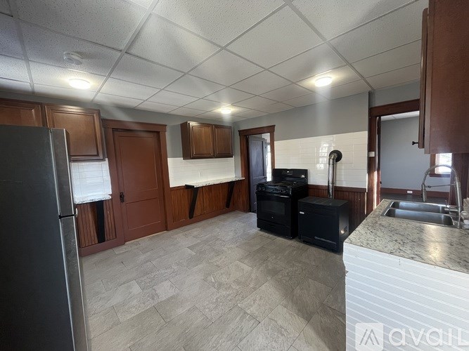 A kitchen with a refrigerator, oven, microwave, and sink.
