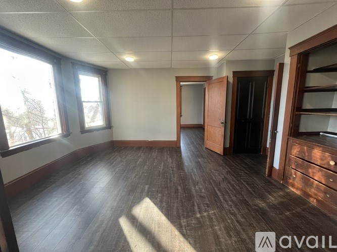 A room with wooden floors and a large window.