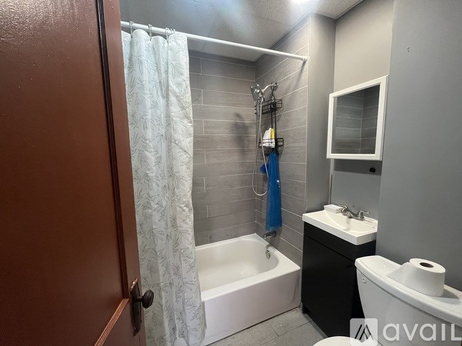 A bathroom with a white tub, sink, and toilet.