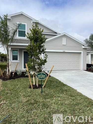 A house with a sign that says "For Rent" in front of it.