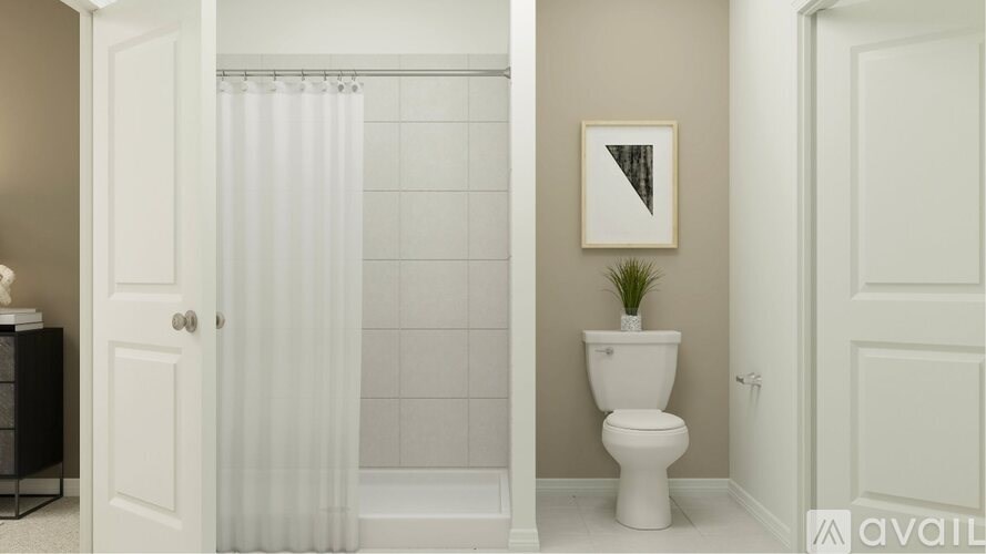 A white toilet sits next to a white shower curtain in a bathroom.