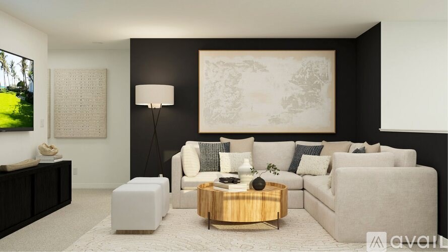 A living room with a grey couch, a white ottoman, a wooden coffee table, and a large painting on the wall.