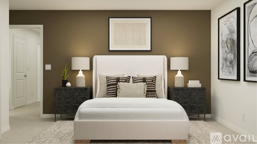 A bedroom with a large bed, two nightstands, and a framed picture on the wall.