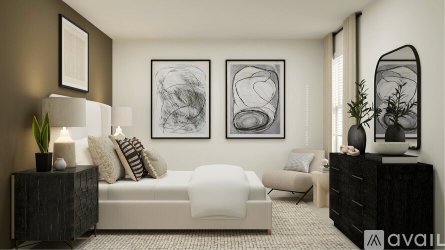 A modern bedroom with a large bed, a white chair, and two framed artworks on the wall.