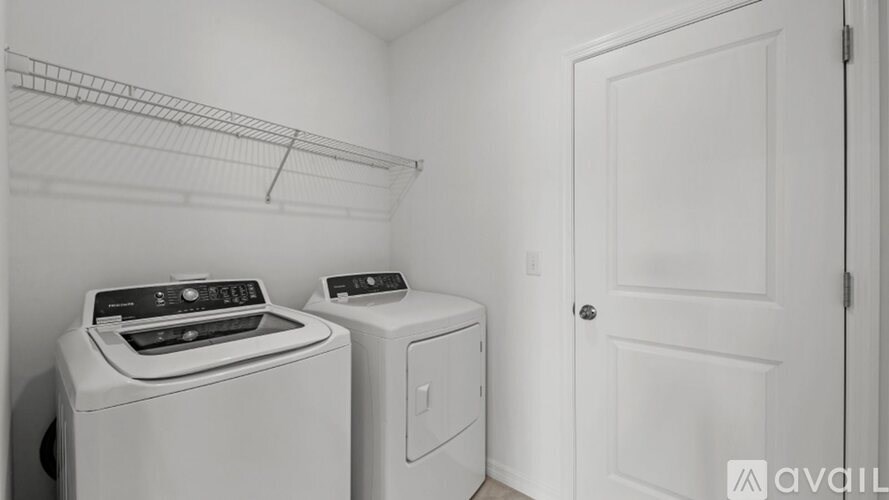 A laundry room with a washer and dryer and a door.