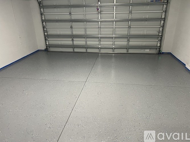 A spacious garage with a closed metal shelving unit.