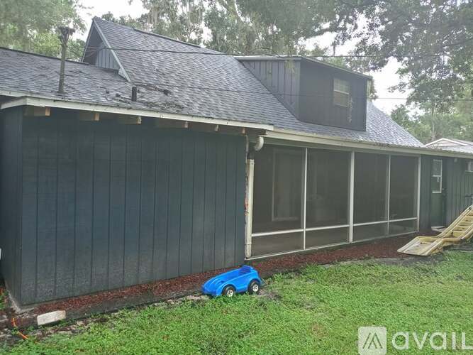 A blue toy car is parked in front of a black building.
