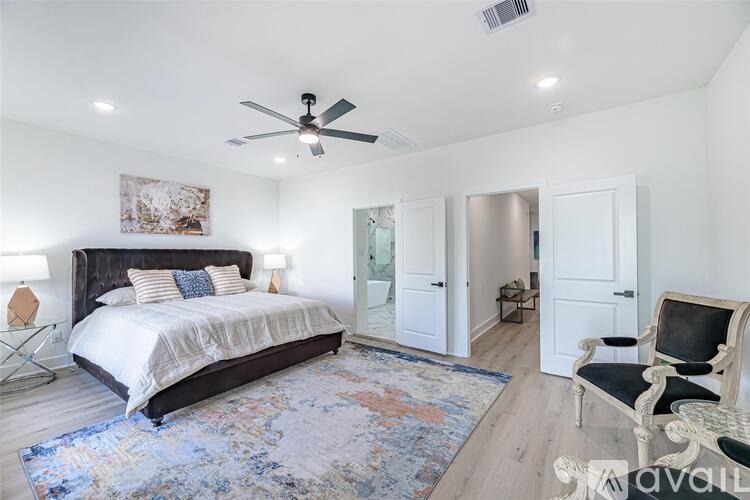 A bedroom with a large bed and a ceiling fan.