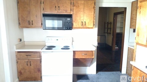 A kitchen with wooden cabinets and a white stove top oven.