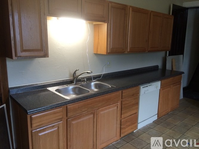 A kitchen with wooden cabinets and a black countertop.