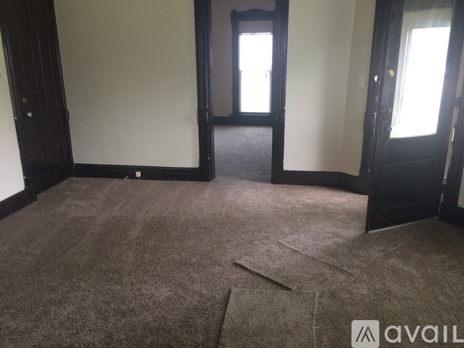 A room with a carpeted floor and a door.