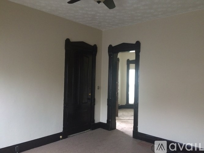 A room with a black door and a mirror on the wall.