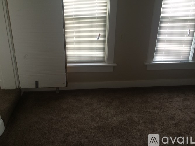 A room with two windows and a carpeted floor.