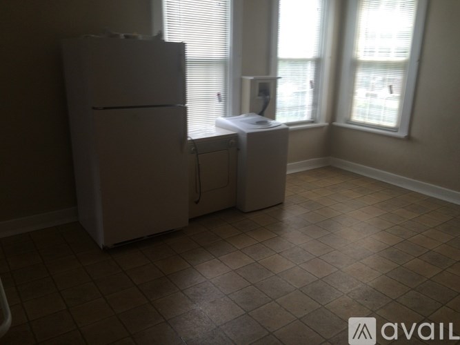 A white refrigerator and dishwasher in a kitchen with tiled flooring.