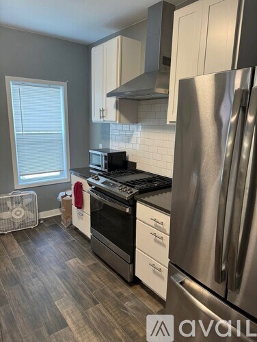 A kitchen with a stainless steel refrigerator, oven, and microwave.