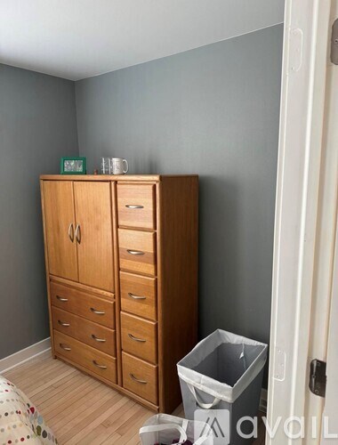 A wooden cabinet with drawers and a green sign on top.