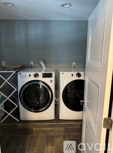 Two white front load washing machines in a laundry room.