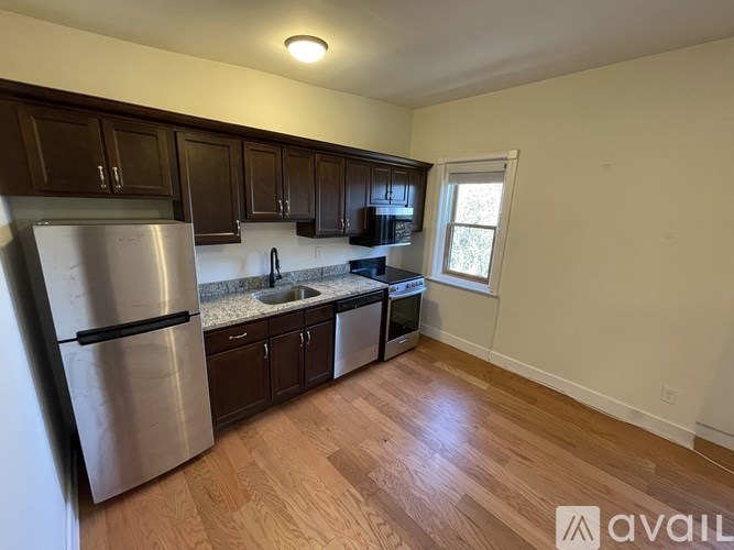 A kitchen with wooden cabinets and a stainless steel refrigerator.