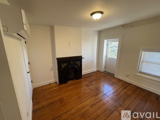 A room with a fireplace and wooden floors.