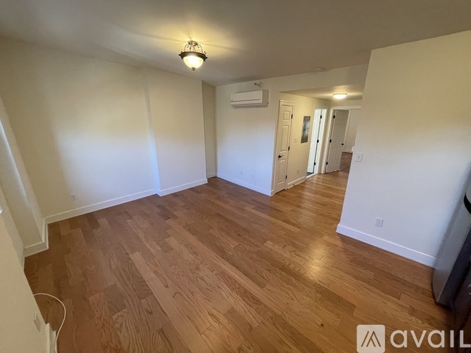 A room with wooden flooring and a ceiling light.
