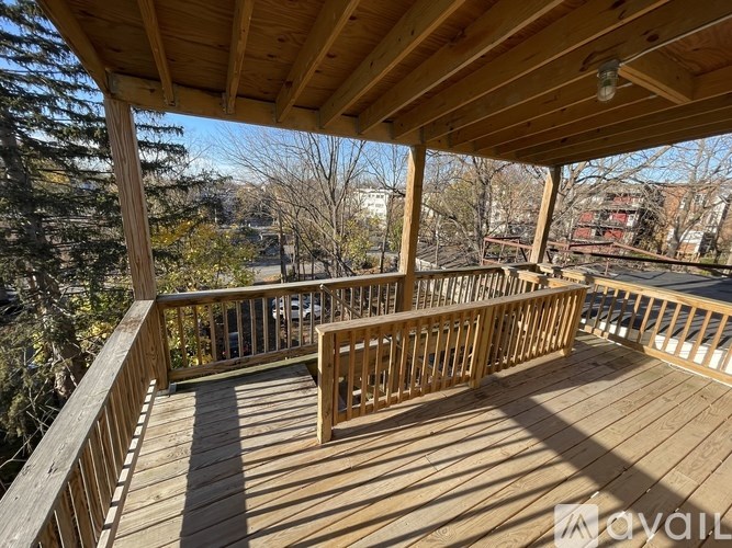 A wooden deck with a table and chairs overlooking a cityscape.
