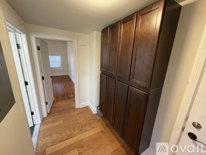 A hallway with wooden floors and white walls.