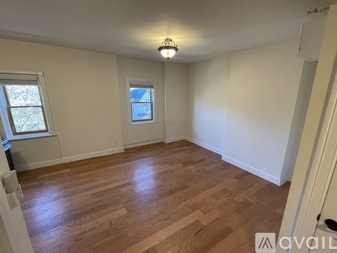 A room with wooden flooring and a window.
