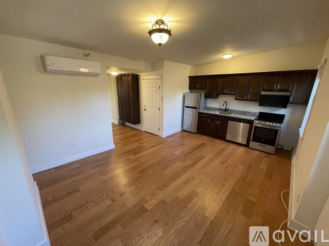 A kitchen with wooden floors and a white ceiling.
