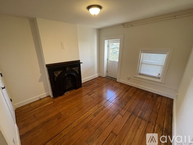 A room with a fireplace and wooden floors.