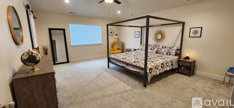 A bedroom with a four poster bed and a dresser.