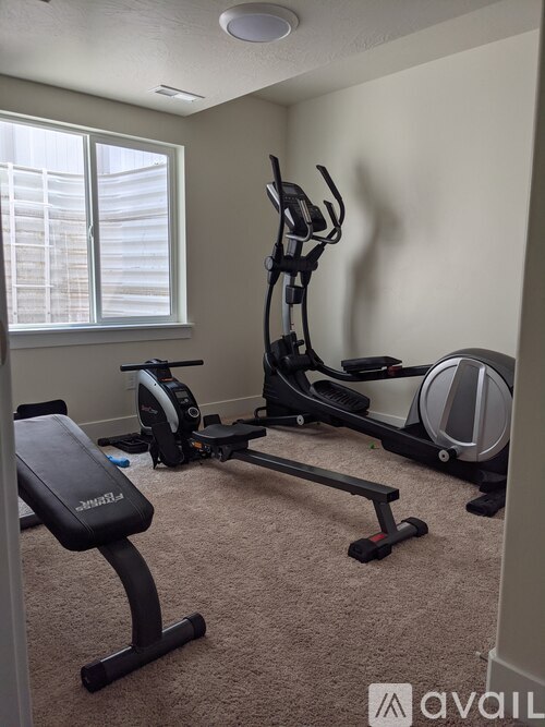 A home gym with a treadmill, elliptical trainer, and stationary bike.