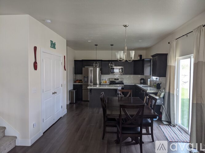 A kitchen with a dining table and chairs.