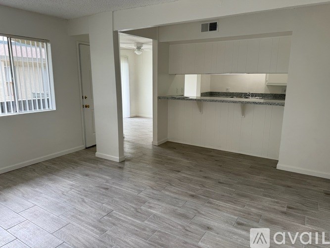 A spacious room with a grey floor and white walls.