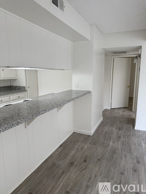 A kitchen with white cabinets and a granite countertop.