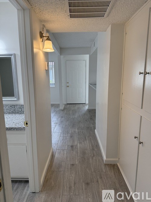 A hallway with white doors and a grey floor.