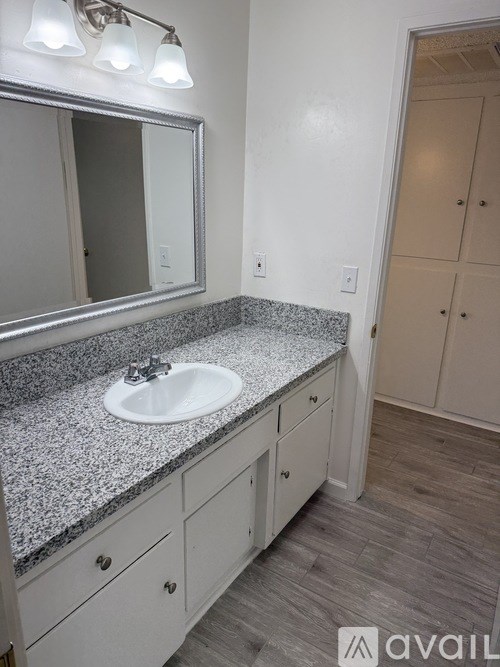 A bathroom with a granite countertop and a white sink.