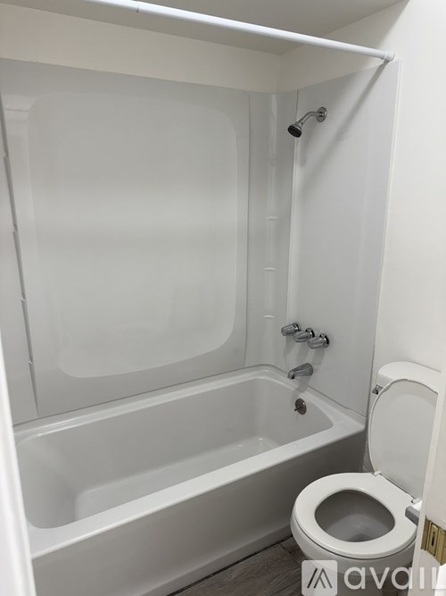 A white bathroom with a toilet and a bathtub.