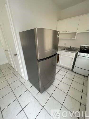 A kitchen with a stainless steel refrigerator and white appliances.