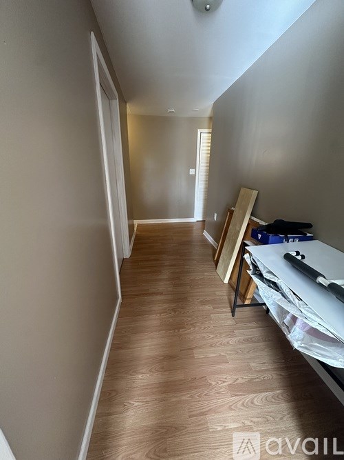 A long hallway with a wooden floor and white walls.