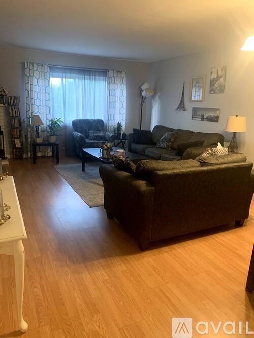 A living room with a couch, chair, and lamp.