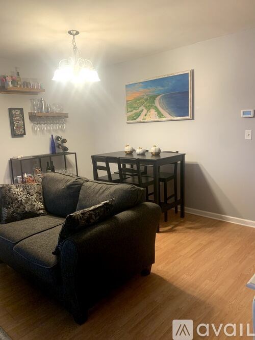 A living room with a sofa, a table, and a painting on the wall.