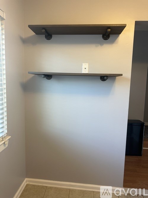 A wall with a shelf and a white light switch.