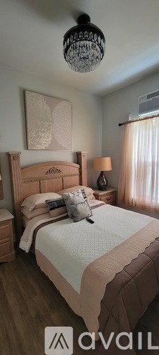 A bedroom with a bed, nightstand, and lamp.