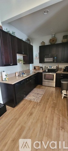 A kitchen with dark wood cabinets and a light-colored countertop.