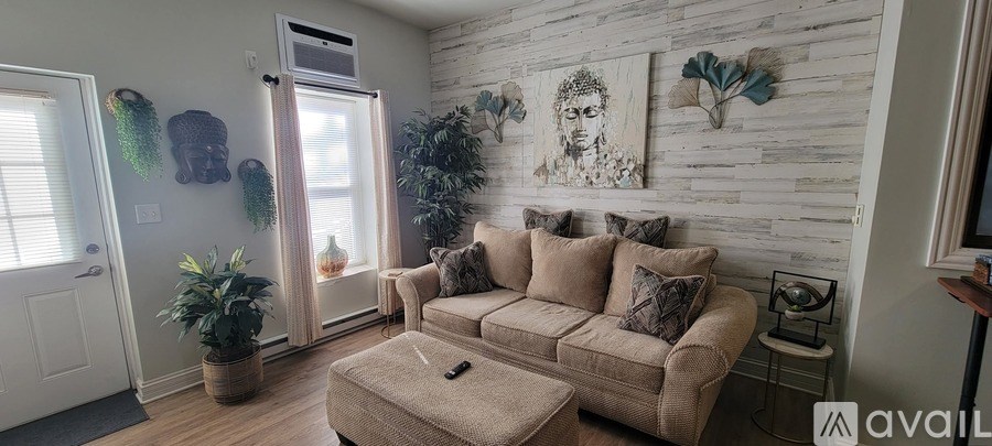 A living room with a couch, a coffee table, and a plant.